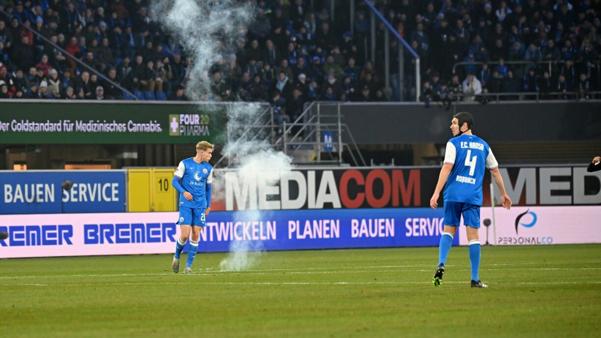 Bild: Rostocker Anhänger schmissen Pyrotechnik auf den Rasen (© IMAGO/Ulrich Hufnagel/IMAGO/Ulrich Hufnagel/IMAGO/Ulrich Hufnagel)